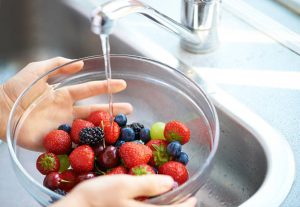 berries getting washed under the sink
