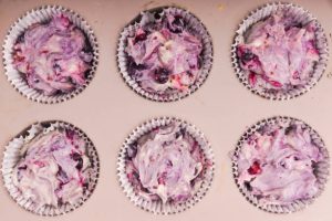 dough for muffins with berries in the form