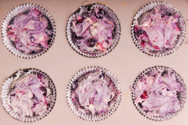 dough for muffins with berries in the form