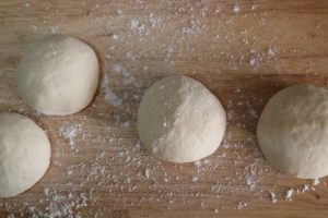 Dough ball of flour on a cutting board / Wooden board with flour and dough / Ingredients for baking