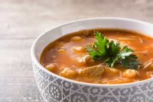Harira soup in bowl isolated on wooden table table. Typical Moroccan food. Ramadan concept.