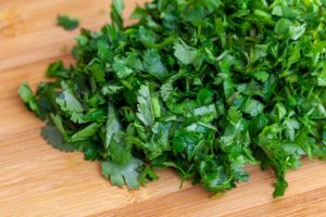 Chopped parsley on a wooden chopping board. greenery