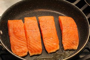 Closeup of Fresh Salmon Fillets Searing in Pan